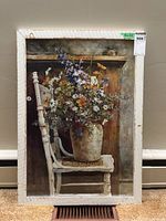 Full view of framed print depicting wildflowers in a rustic vase on a white chair with wooden background.