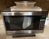 Front view of Panasonic stainless steel inverter microwave with digital keypad and display showing time.