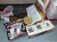 Lot contents showing boxed Black & Decker planer, boxed Makita disc sander, and various vent covers and parts including white and brown metal vents and duct connector.