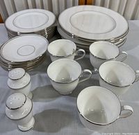 Full set of Lenox Federal Platinum Collection dinnerware with plates, cups, saucers, and salt and pepper shakers on a table.