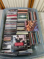 Top overview of plastic bin container filled with assorted CDs from various easy listening and vintage artists like Michael Bublé, Il Divo, and Pentatonix.