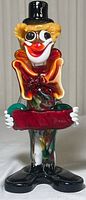 Full front view of Murano glass clown figurine showing head to feet and bowl held in front.