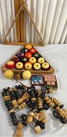 Overview photo showing billiard balls, wooden racks, scoring beads, and other game accessories arranged on table.