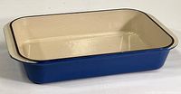 Front angled view showing blue enamel exterior and cream interior of the rectangular casserole dish.
