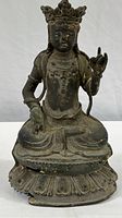 Front view of seated Tibetan Bronze Buddha on double-lotus base showing overall form and posture.