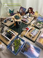 Close up of sewing materials showing pin cushions, scissors, needles, threads, and various containers of sewing pins and needles.