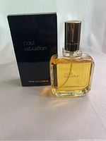 Paired photo showing Paul Sebastian cologne bottle with amber liquid and original black box.