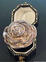 Close-up of the rose flower shaped ring in black jewelry box, showcasing shape and design.