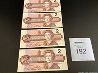 Four sequential 1986 Canadian two dollar bills laid out showing front side with Queen Elizabeth II portrait and denomination '2'.