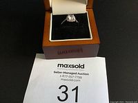 Estate ring displayed in open brown and cream ring box on black background with MaxSold auction paper #31 below.