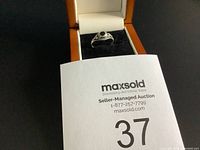 Close-up of the estate ring with black stone showcasing the detailing on the band and setting, box included for displaying.