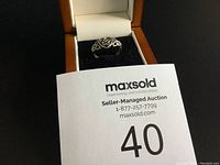 Front view of the silver Celtic knot ring inside black velvet jewelry box with wooden exterior.