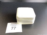 Closed white square zippered jewelry box on black surface