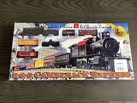Top view of the boxed Presidents Choice 2-6-0 Camelback Express train set showing locomotive, tender, and rail cars through clear packaging, with box label and artwork.