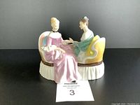 Front view of the Royal Doulton Heart To Heart figurine showing both women seated on a decorative bench.