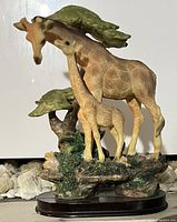 Giraffe figurine showing adult giraffe and calf with greenery and textured base