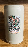 Front side showing detailed colorful relief of man in traditional clothes and German dialect text on ceramic stein