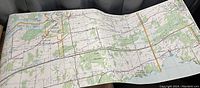 Photo of a large unfolded map spread out showing terrain, roads, and water features