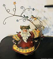 Metal Santa Claus figurine with attached decorative wire branches featuring metal hearts, stars, and birds.