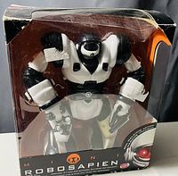 Clear front view of the boxed Robosapien robot toy in black and white colors showing the figure inside the packaging.