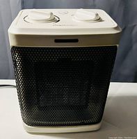 Front view of Pro Breeze heater showing white top with control knobs and black mesh front panel.