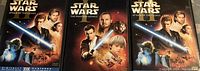 Three Star Wars DVD cases showing cover art for Attack of the Clones (two copies) and The Phantom Menace (one copy).