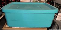 Photo of a large sturdy teal storage tote with fitted lid, clean and in good condition.