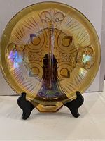 Front view of amber carnival glass divided dish showing intricate flower and fan patterns with iridescent finish on stand (stand not included).