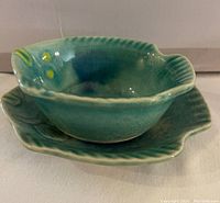 Photo of fish-shaped bowl resting on matching fish-shaped plate, showing shape and glaze.
