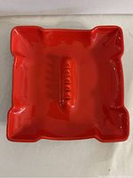 Top view of red ceramic serving tray showing overall shape and integrated handle design.