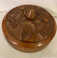 Closed wooden bowl showing the floral carved lid with knob