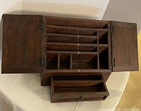 Top view of open wooden secretarial box lap desk showing compartments and pull-out drawer