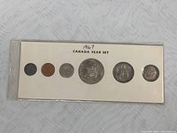 Full display card with 5 coins labeled '1967 CANADA YEAR SET'. Coins arranged left to right: 1 cent, 10 cent, 1 dollar, 50 cent, 25 cent.