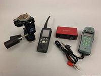 Photo showing all items together: Manfrotto tripod head, Focusrite Solo USB audio interface, two handheld communication devices, audio cable