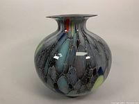 Front angle view of the Murano glass vase with colorful design and flared rim.