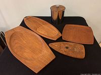 Photo showing all four teak wood trays and stainless steel ice bucket on black cloth background