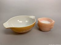 Photo showing Pyrex mixing bowl and stack of six peach Anchor-Hocking casseroles