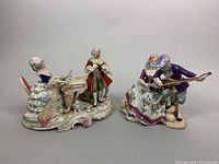 Two vintage porcelain figurines side by side on gray surface showing overall scale and style