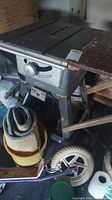 Front view of vintage Craftsman table saw on metal stand with wheels and adjuster knob