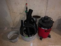 Photo showing galvanized tubs next to Shop-Vac wet/dry vacuum in basement setting.