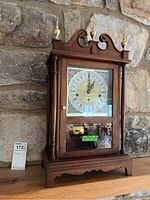 Full view of the Howard Miller wooden pendulum case clock showing overall shape, styling, and height.