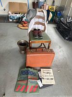 Full lot overview showing suitcase, chair with boots, trophy vase, and vintage books and cloth bags on floor