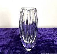 Front view of Baccarat crystal vase showing clear vertical fluting and bowed three-sided shape.