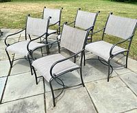 Five chairs arranged on stone patio, front three and back two view