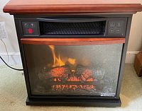 Front view of Duraflame electric infrared fireplace heater with lit flame effect.