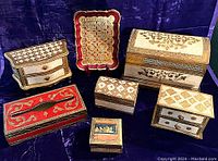 Full view of all seven assorted Florentine decorative boxes and one tray on dark fabric background