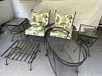 Full view of two chairs with cushions, two end tables, ottoman base, and tea cart on porch