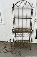 Front view of four-tier metal bakers rack with two matching planter holders beside it