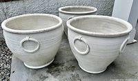 Three large white terra cotta garden urns viewed from above showing size and shape
