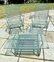 Overview of two chairs, ottoman base and glass top on patio